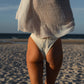 woman wearing a white bikini and cover-up on a beach